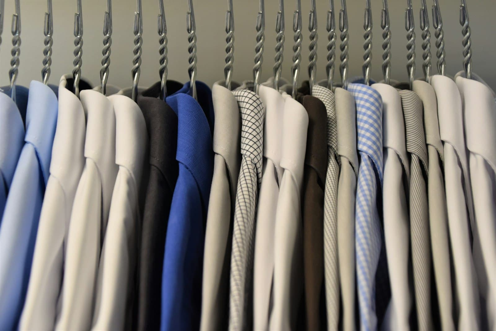 Rad av kostymskjortor på dry-cleaner-galgar